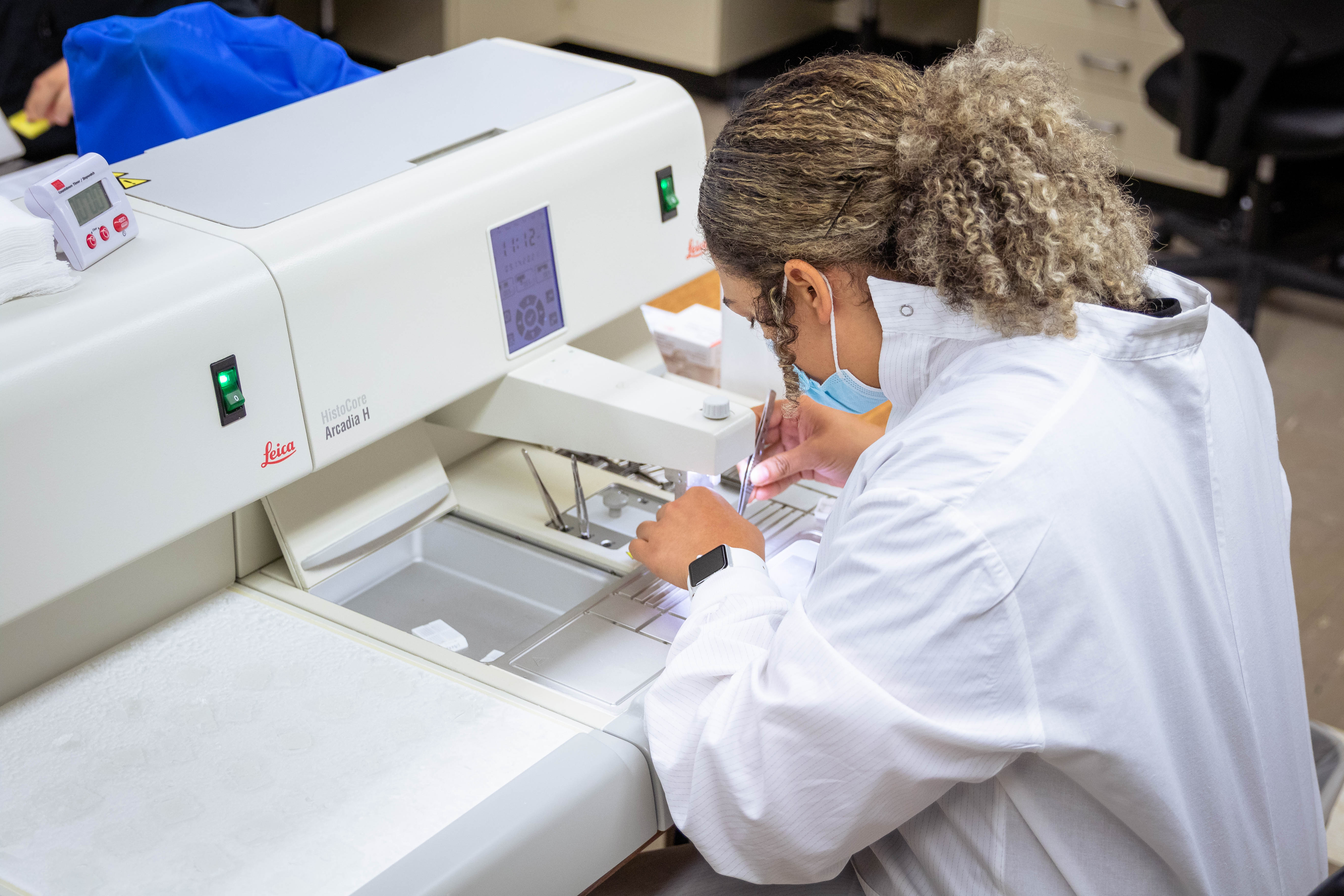 Female student works in biomedical laboratory diagnostics lab on equipment