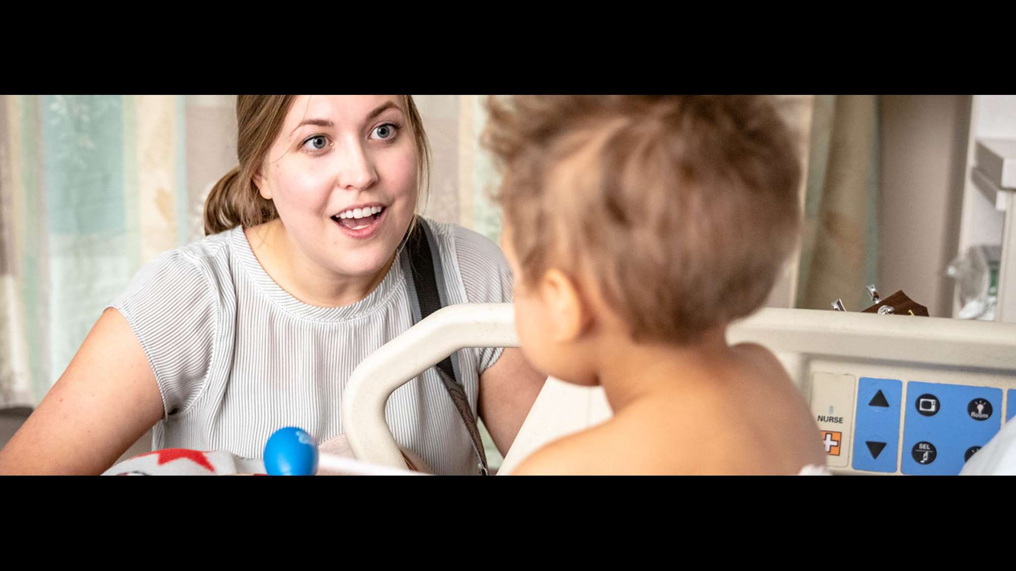 Music therapist plays guitar for pediatric patient