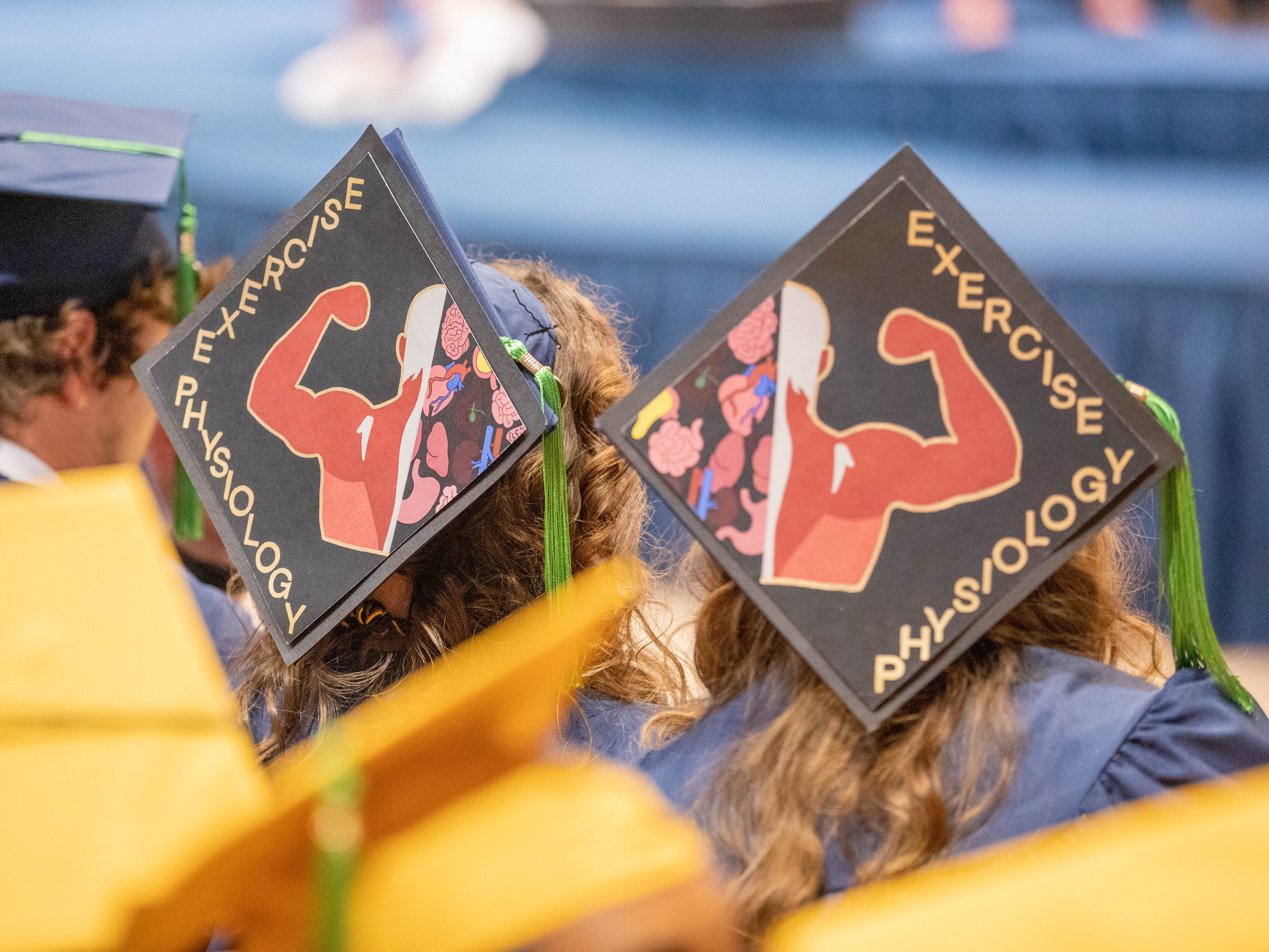 Graduation caps from spring commencement 2022 that read "exercise physiology"