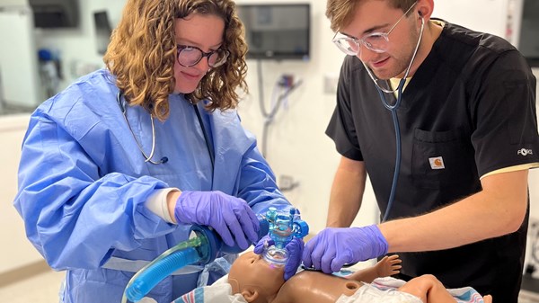 Students work with neonate mannequin and breathing equipment