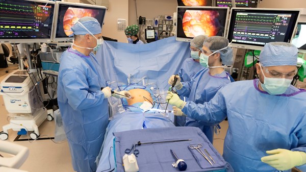 Group of surgeons in operating room performing heart surgery procedure.