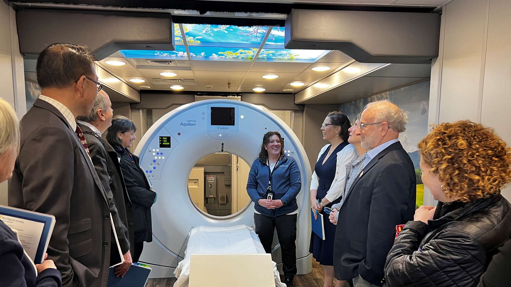 A group of visitors on a tour of the LUCAS low dose CT scanner used for lung cancer screening.