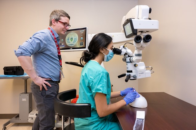 Residency Program Director Bradley Thuro, M.D. observes a resident as they practice using the EyeSi Surgical Simulator