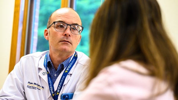 Program Director Ryan McCarthy, M.D., discusses a patient treatment plan with a resident