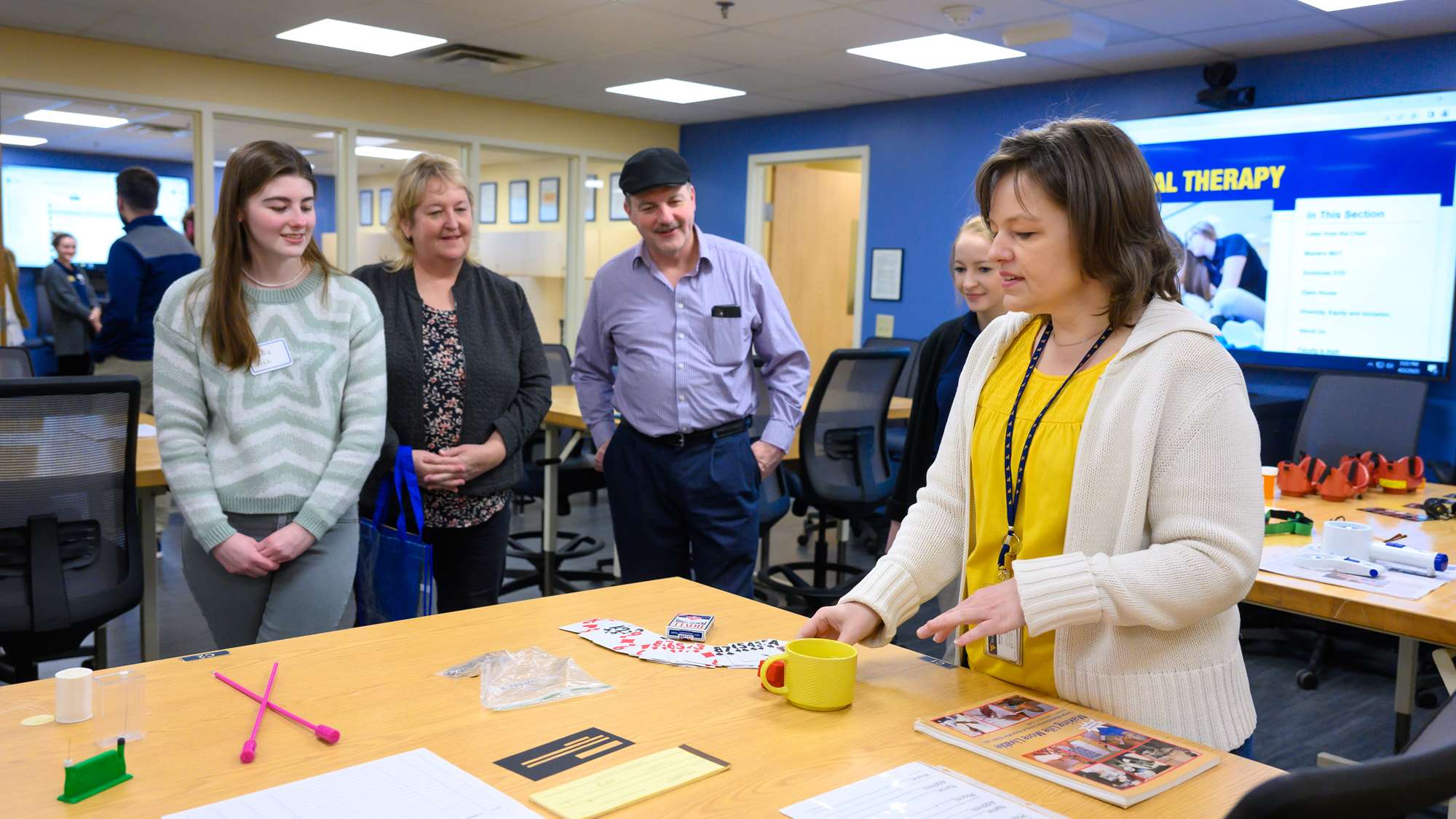 Faculty member explains tools on table to group