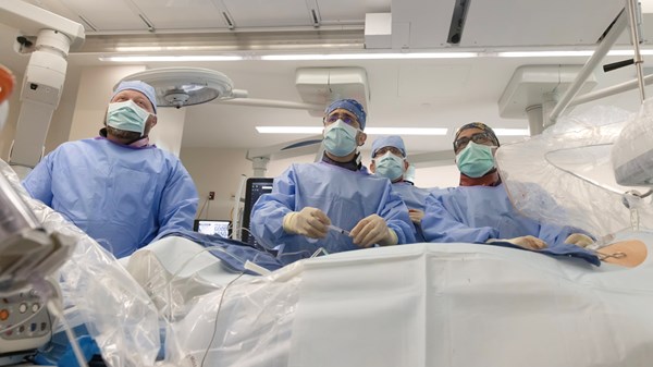 Group of surgeons in operating room performing procedure