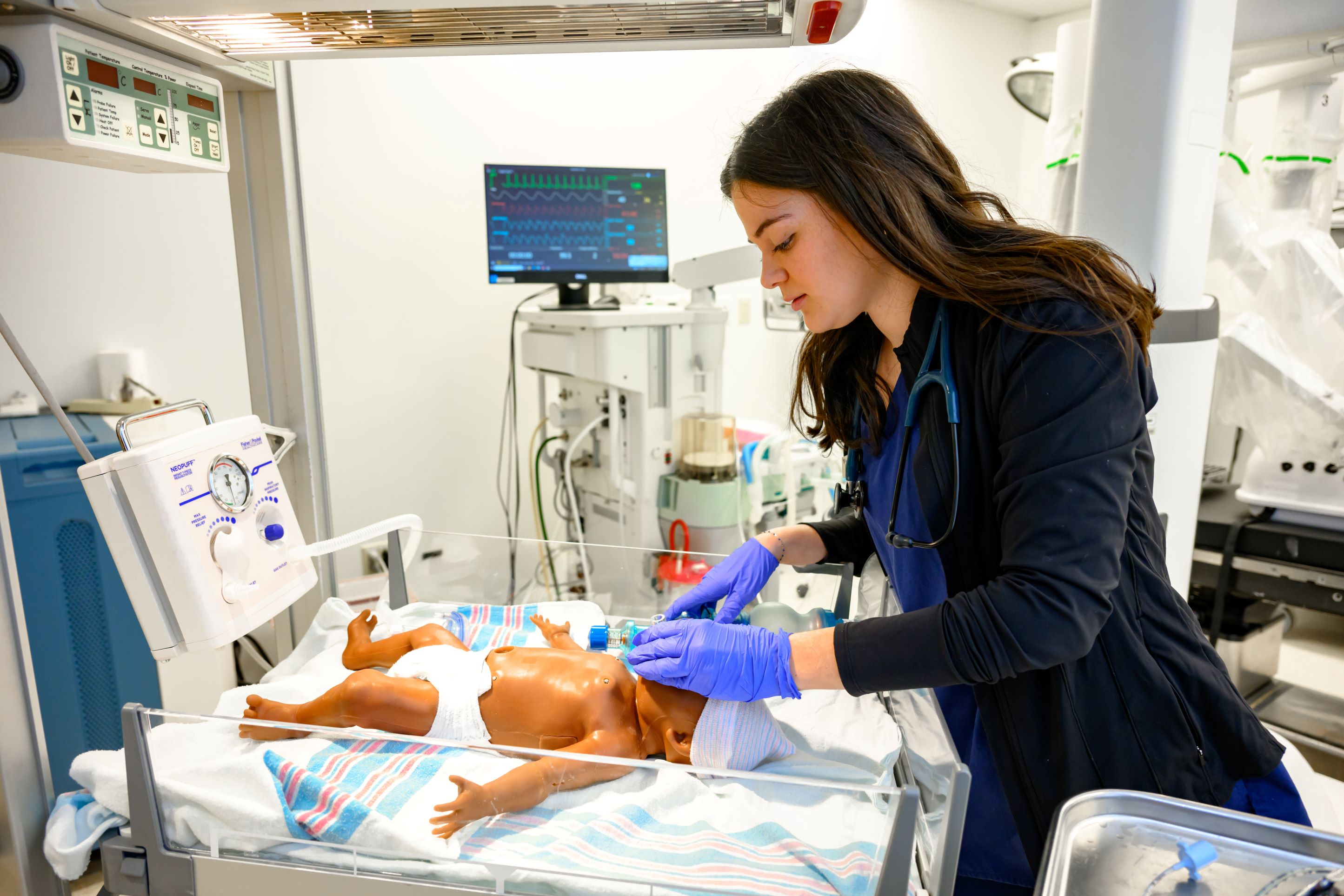 Respiratory therapy student practices techniques with neonatal mannequin
